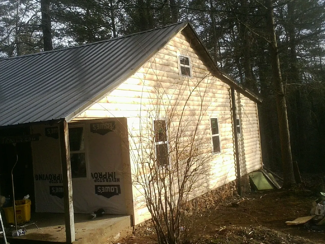 Log siding gable end under a dark metal roof edge in Hot Springs