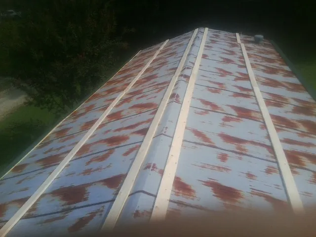 Rusted metal roof panels with new wood purlins before replacement — Storm Damage Roof Repair in Hot Springs by Roofing Brothers