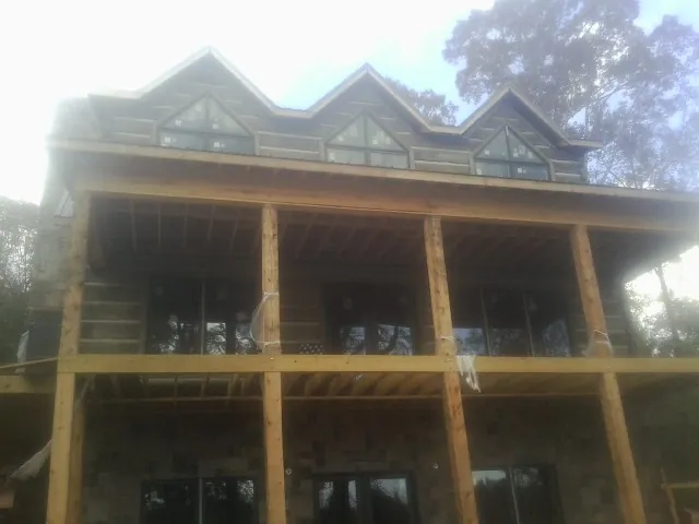 Dormers and porch framing on a large log home under construction — Roof Coating work by our crew in Hot Springs