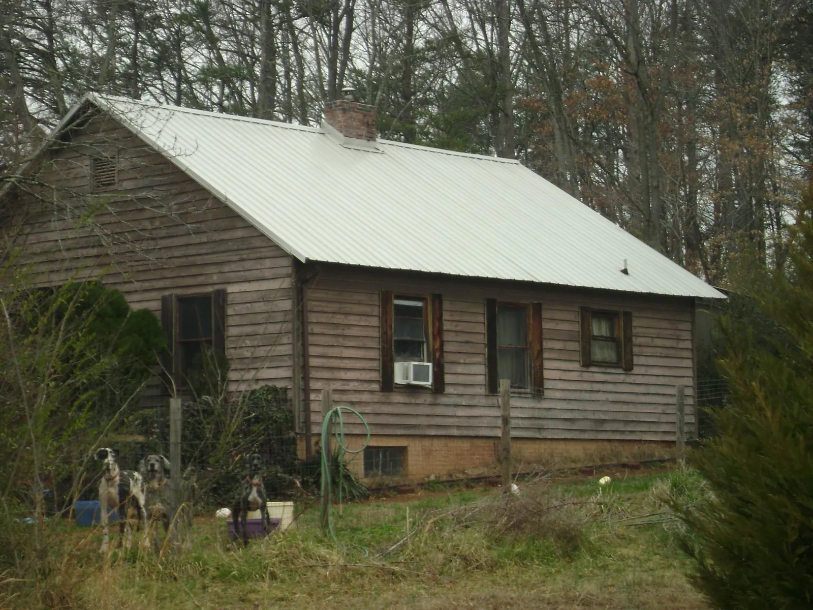 White metal roof on an old wood sided farmhouse, from a Asphalt Shingle Roof Repair job in Hot Springs